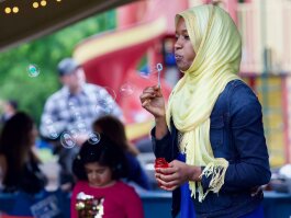 A girl blows bubbles at the 2019 World Refugee Celebration in downtown Fort Wayne.