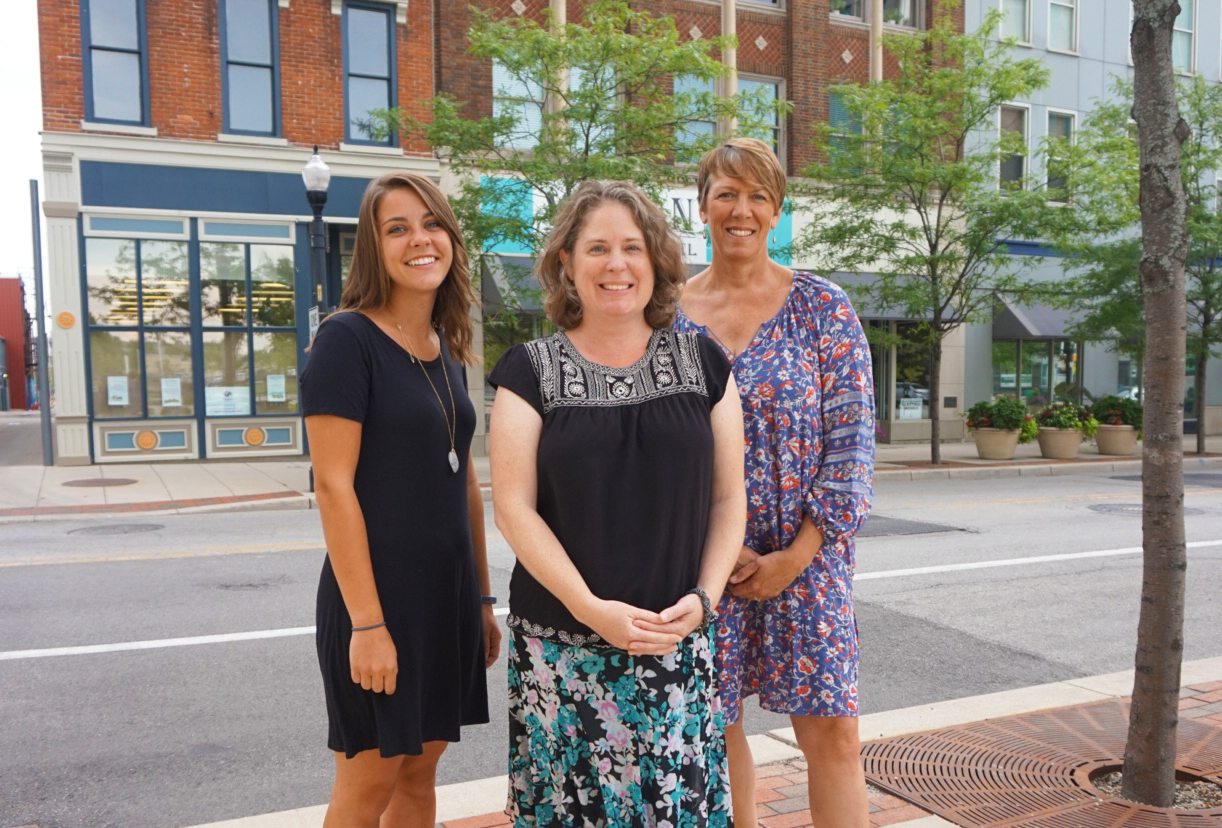 Aubrie Tinsley (left), Sara Gensic (center), and Suzy Ulmer (right) in downtown Fort Wayne with the Alyssum Montessori School behind them on the left.