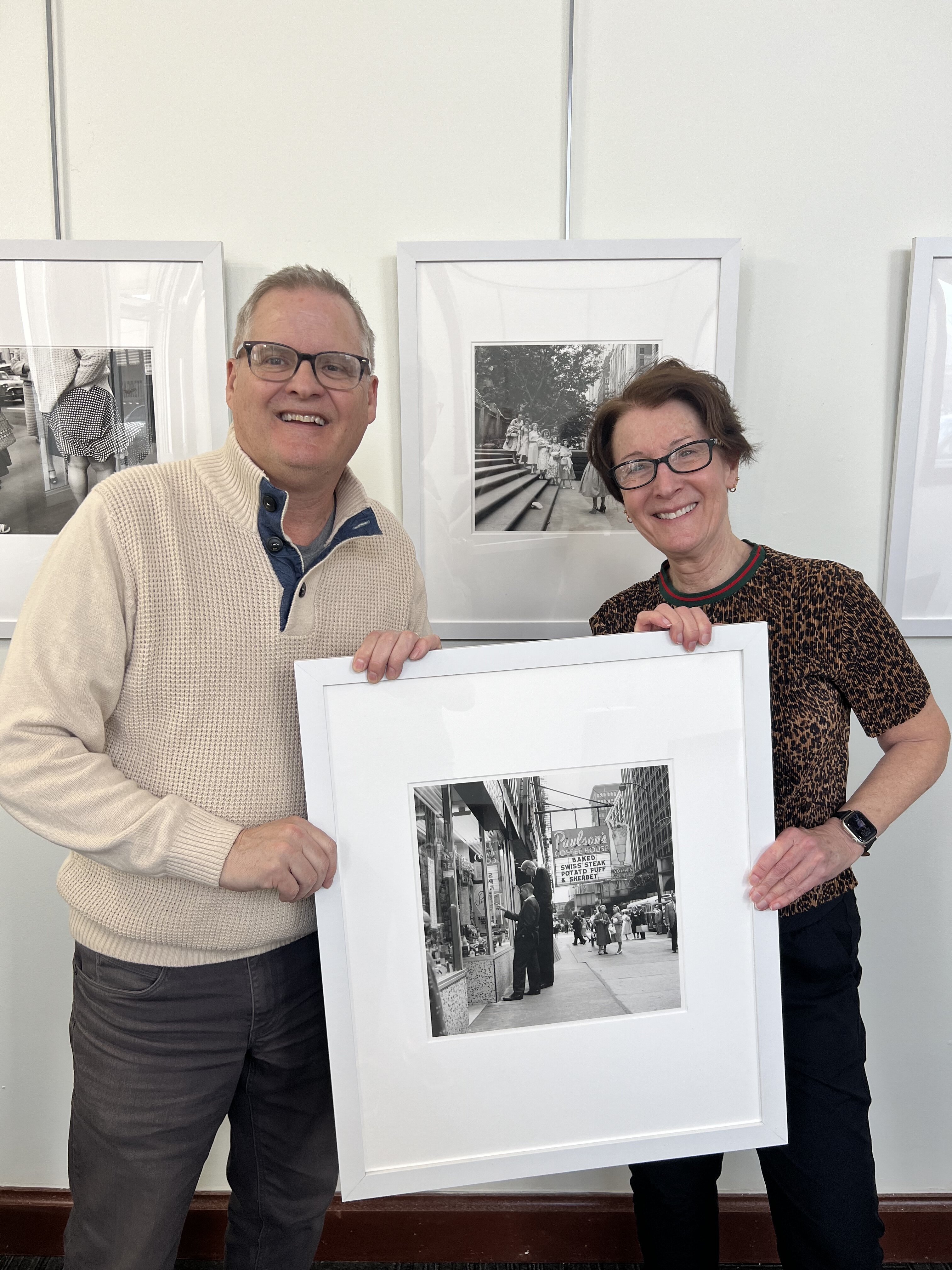 Gallery Coordinator and Curator Angela Green and Museum Director Jim Gabbard install a photograph by Street Photographer Vivian Maier.