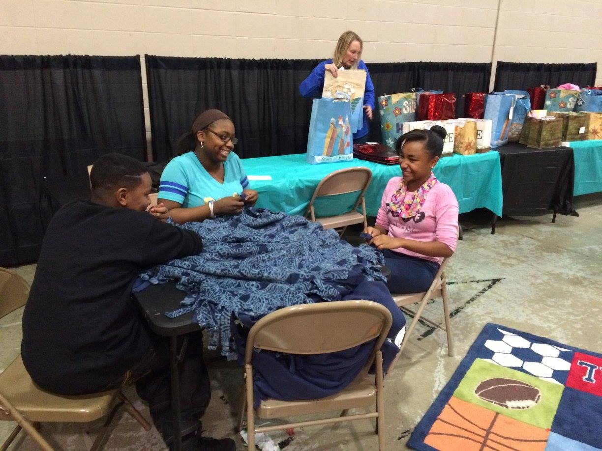 Attendees make fleece blankets together at last year's Holiday Giveback.