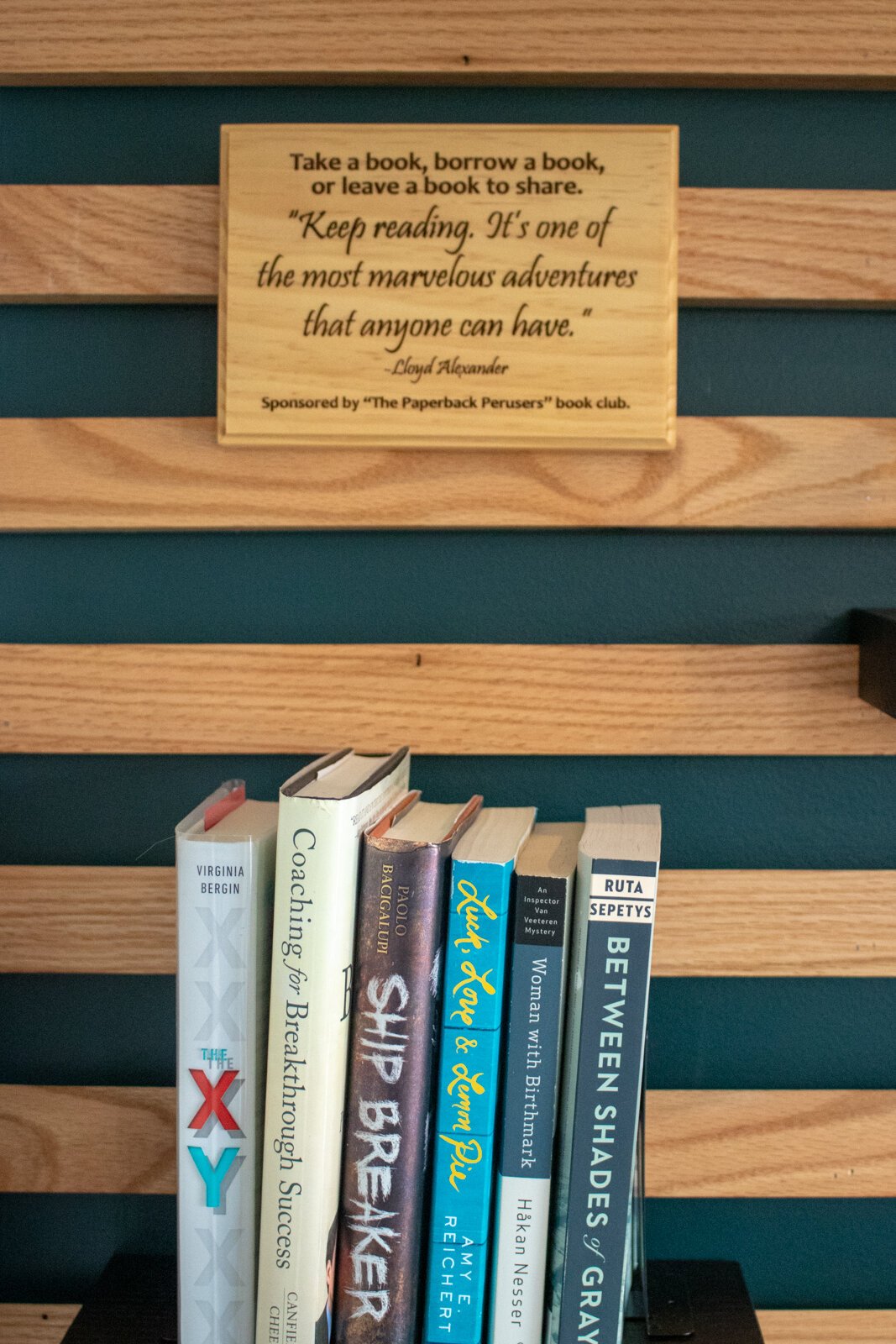 A bookshelf with a "take a book, borrow a book, leave a book" policy.