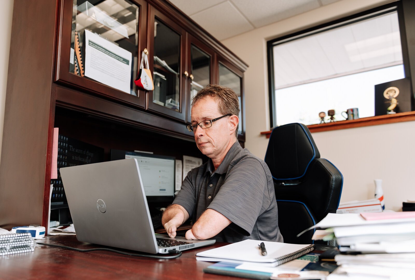 John Guingrich, President/CEO of The League works at his desk at The League For the Blind - Disabled.