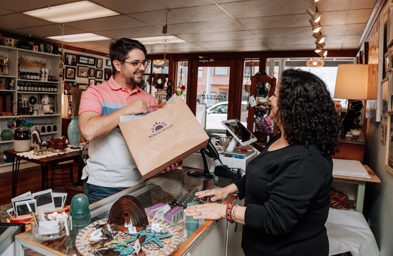 Maria Smith helps customer Mike Barnett with a purchase at Eclectic Shoppe, 42 W Canal St, Wabash, IN.