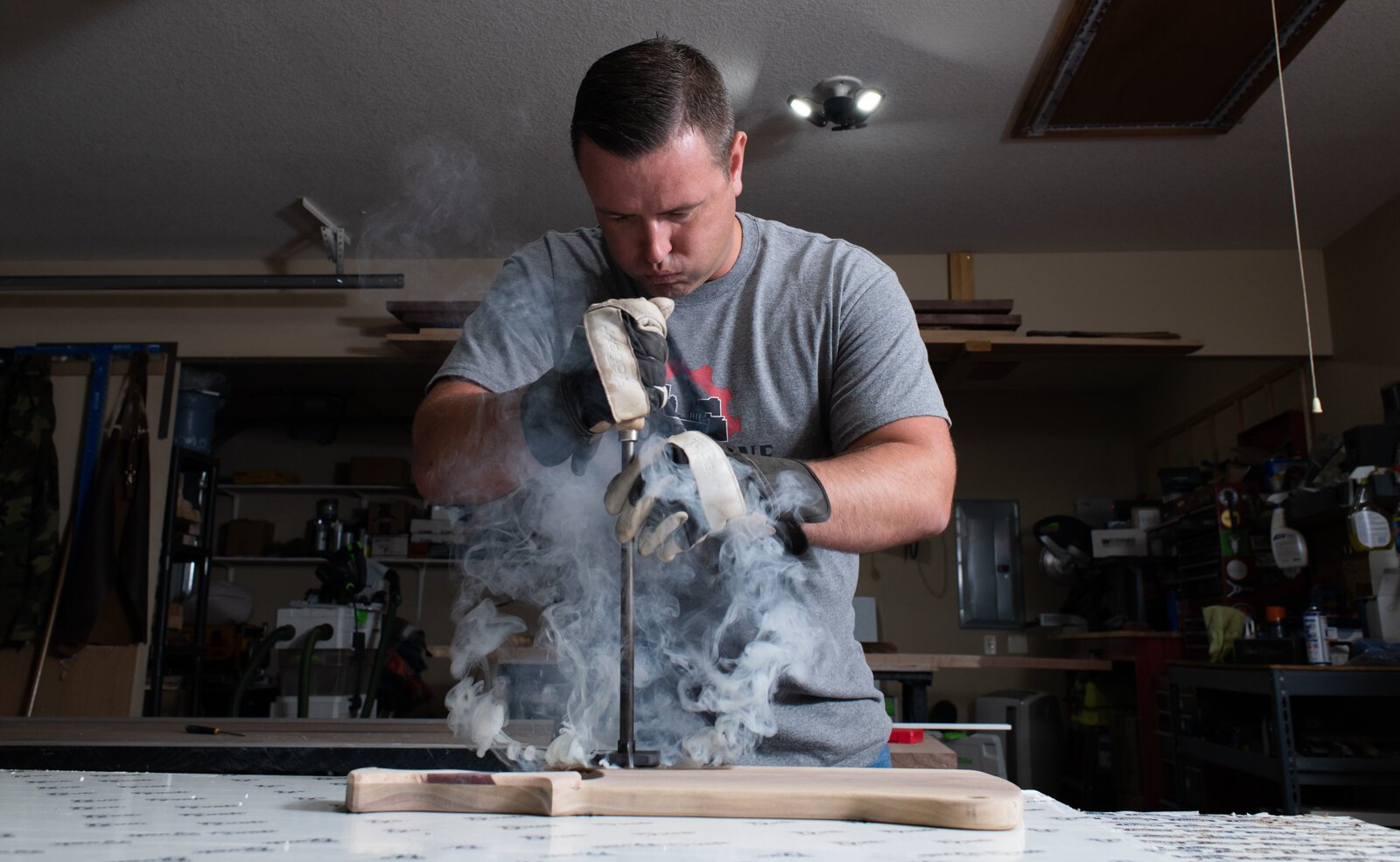 Lee Hoffmeier of Fort Wayne Industrial Revolution brands one of his craft charcuterie boards using a blowtorch.