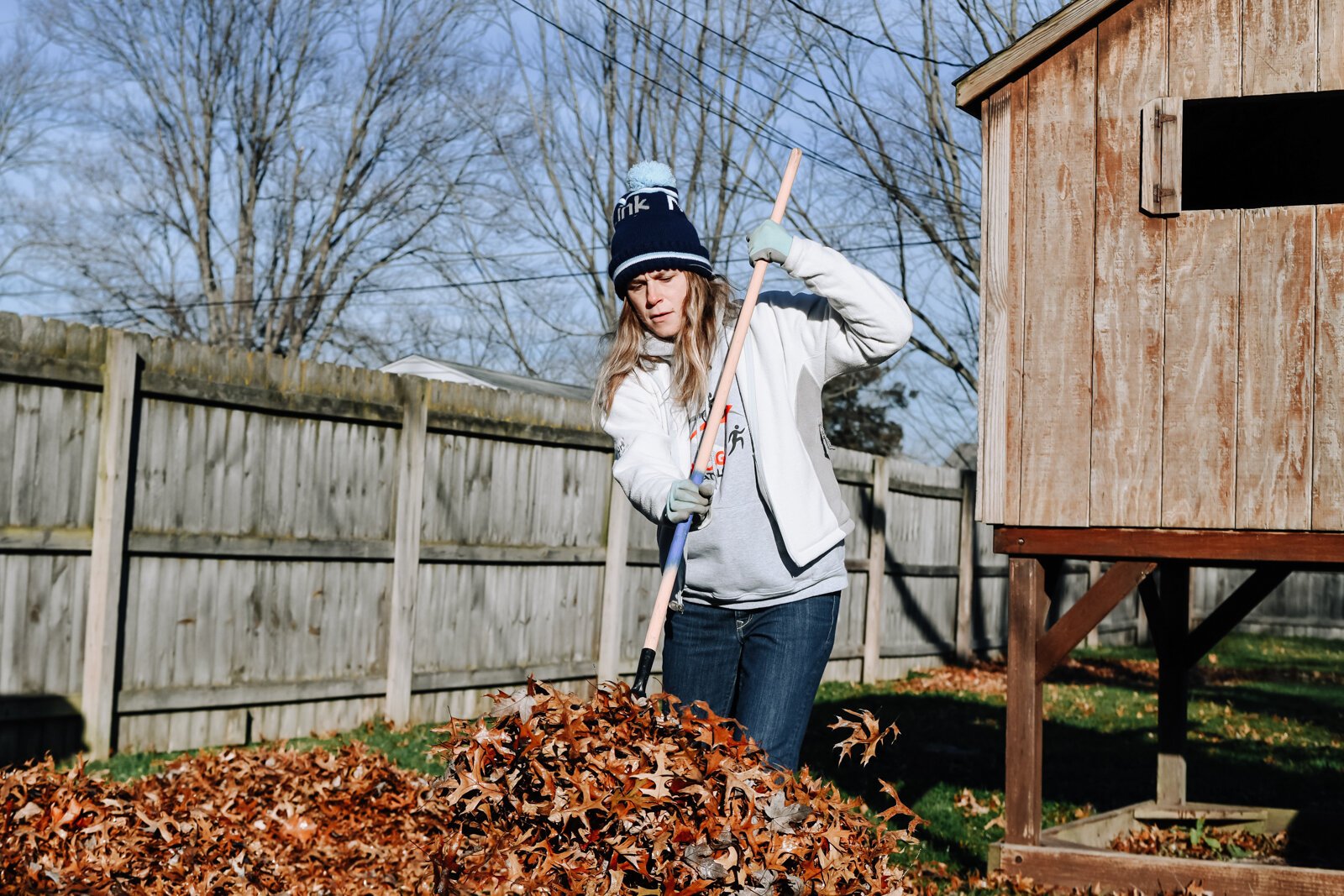 Megan Chandler, Development Coordinator of NeighborLink, helps clear leaves while volunteering at a home in Fort Wayne.