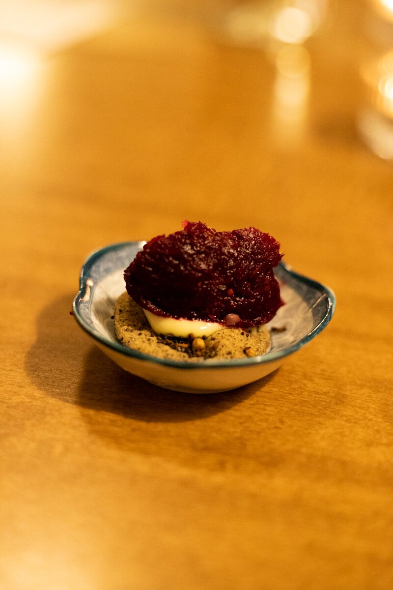 The first course is a sweet and tangy riff on tartare, featuring minced beet atop a seedy, hearty cracker with a layer of garlicky, creamy aioli sandwiched between for a touch of richness.