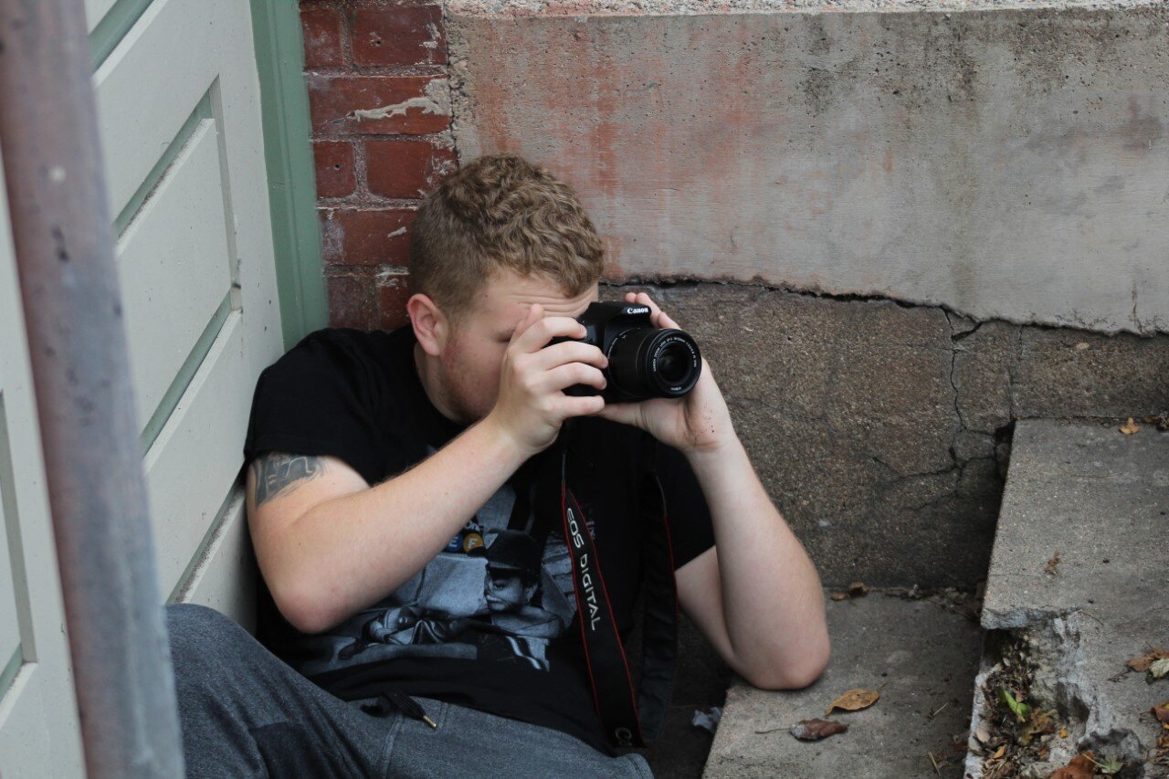 Second-year student, Trenton Moore takes a photograph for his Intermediate Photography class.