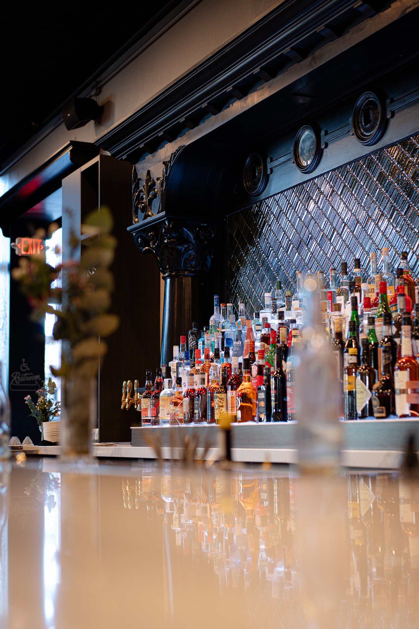 The refurbished back bar features woodworking details and green tiles.