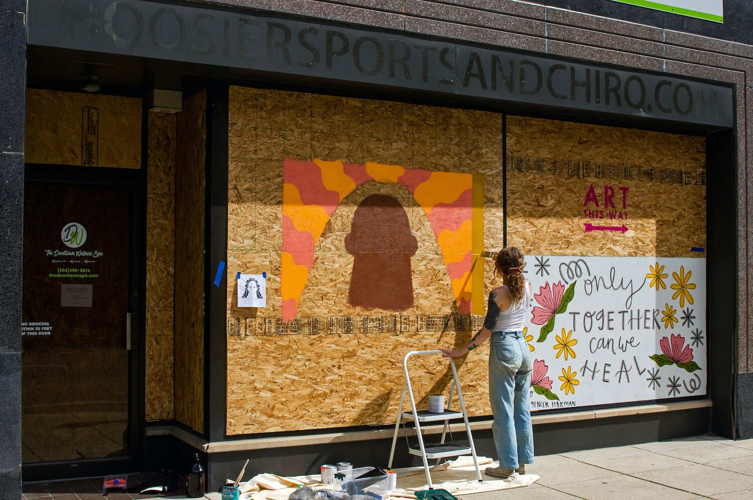 Adeline Griswold paints a mural in downtown Fort Wayne.