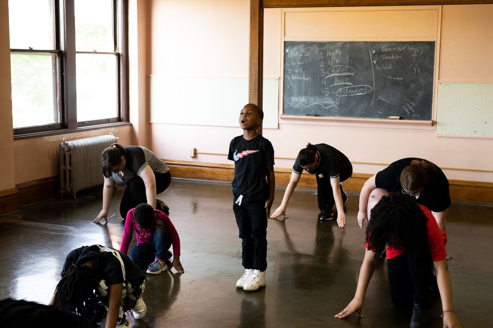 During one set, everyone kneels on the ground and takes turns standing up to announce their names, their parent’s names, their grade levels in school, and their career aspirations.