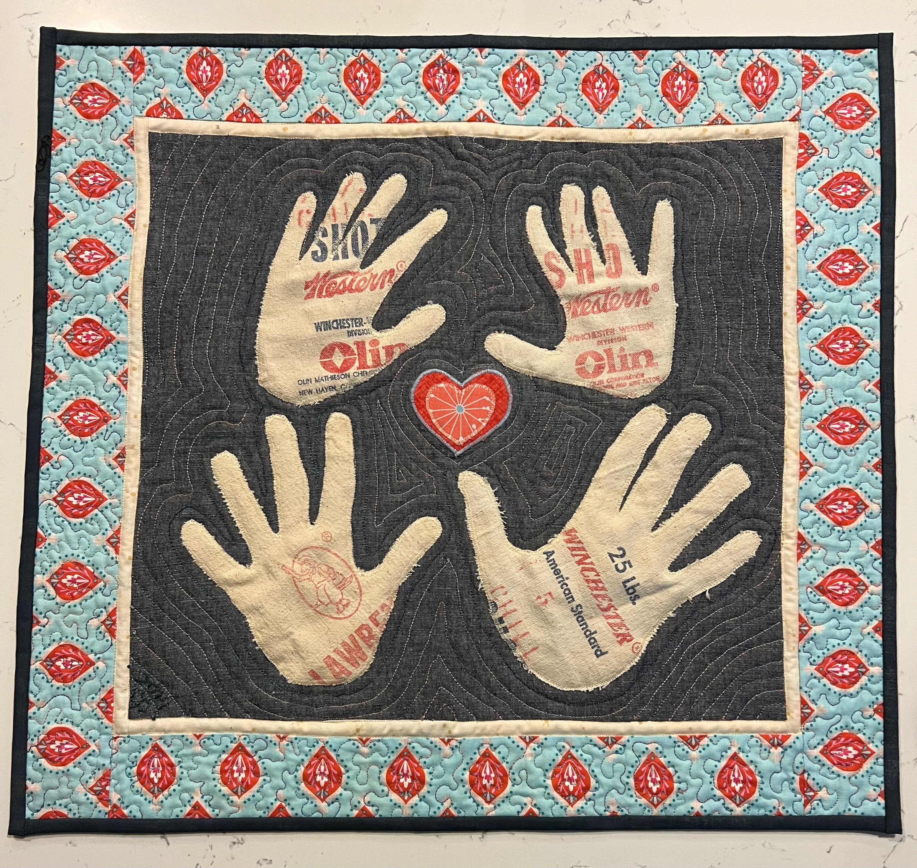 A quilt made by Christine Paul, featuring the handprints of the family it was made for.