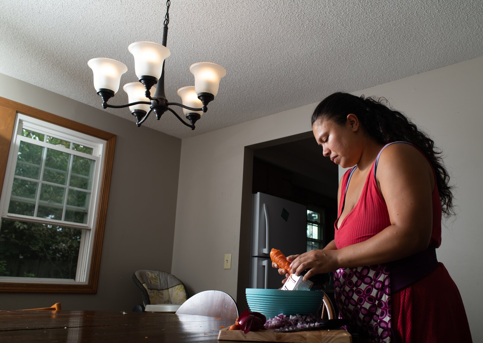 Doula/pregnancy services provider Asha Hernandez works on prepping ingredients for a postpartum meal she cooked in her home in Fort Wayne.