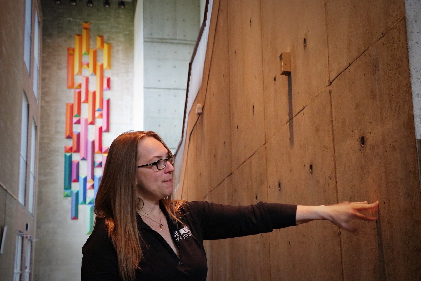 Miriam Morgan, Arts United Chief Operating Officer, looks toward the concrete exterior of the auditorium inside the Arts United Building, a “violin” inside a “violin case.” 