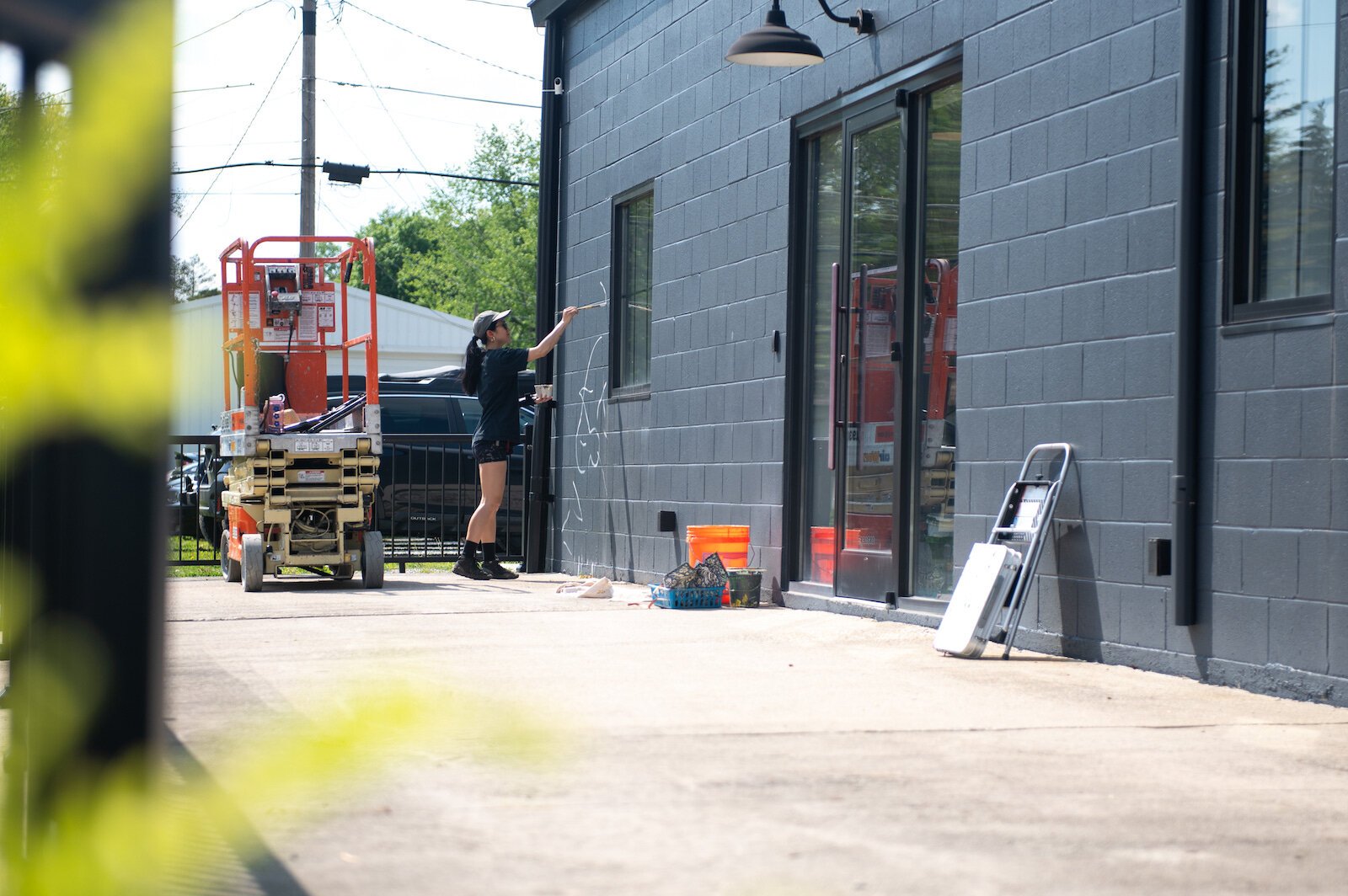 Detroit-based artist Louise 'Ouizi' Jones paints a mural in downtown Roanoke inspired by common Indiana flowers, including peonies and black-eyed Susans.