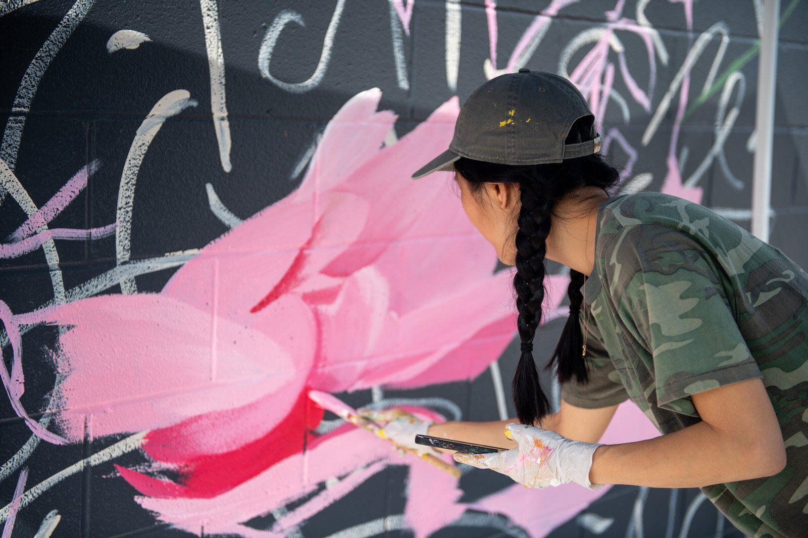 Detroit-based artist Louise 'Ouizi' Jones paints a mural in downtown Roanoke inspired by common Indiana flowers, including peonies and black-eyed Susans.