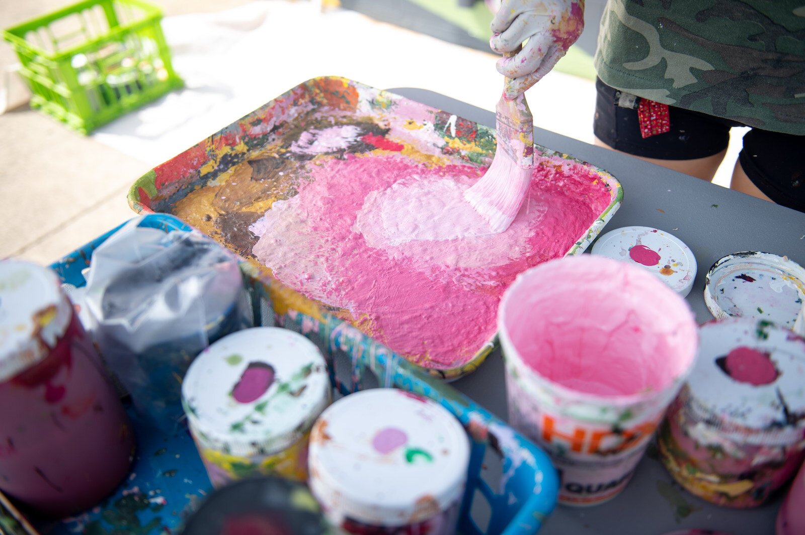 Detroit-based artist Louise 'Ouizi' Jones paints a mural in downtown Roanoke inspired by common Indiana flowers, including peonies and black-eyed Susans.