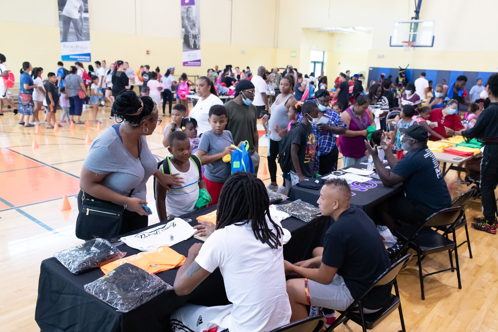 Guests visit the Bigger Than Us table during the Book Bag Giveaway at Renaissance Pointe YMCA, 2323 Bowser Ave. on August 7, 2021. 