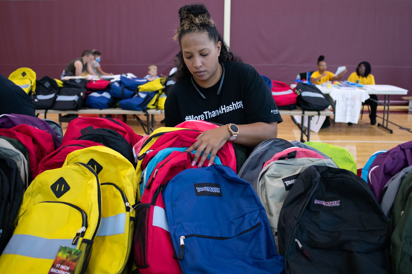 Sajatta Wright, with Bloom Project Inc. works on organizing bookbags during the Book Bag Giveaway at Renaissance Pointe YMCA, 2323 Bowser Ave.