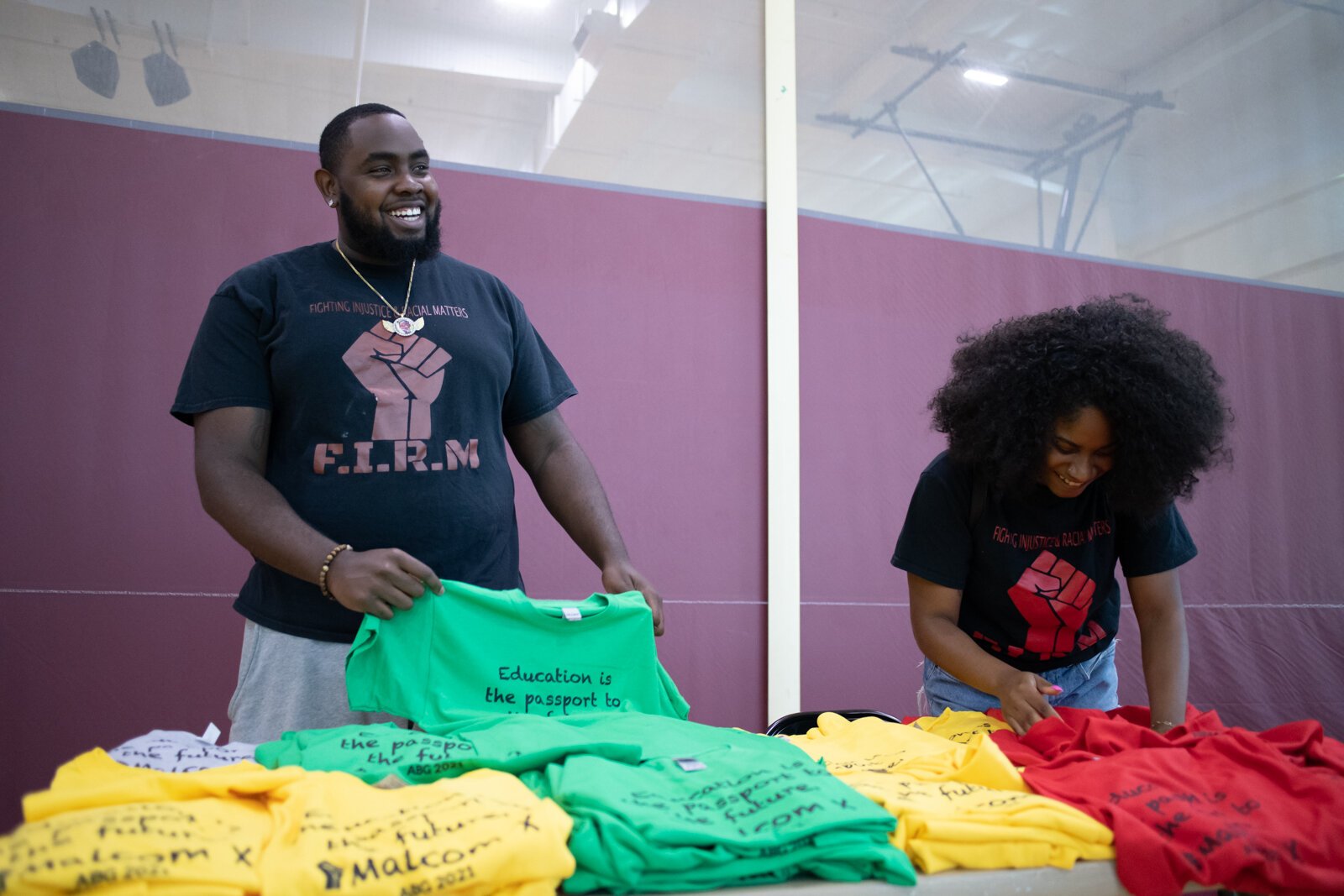James Odom, left, with Firm Inc. and Alex Starks organize the Firm Inc.'s table during the Book Bag Giveaway at Renaissance Pointe YMCA, 2323 Bowser Ave. on August 7, 2021. 