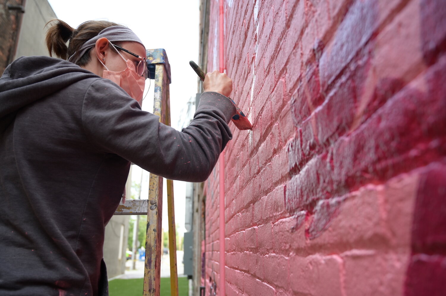 Artists assist Shawn Dunwoody with a mural in downtown Columbia City.