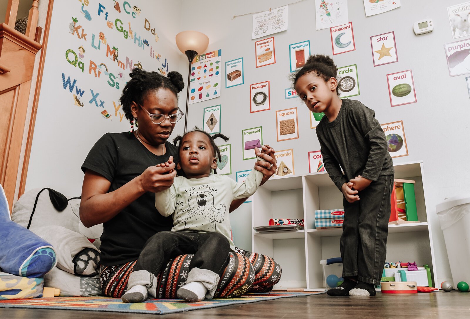 Deondra Steward, Owner of Unique Cherubs takes care of children, JereMias, left, and Domonique.