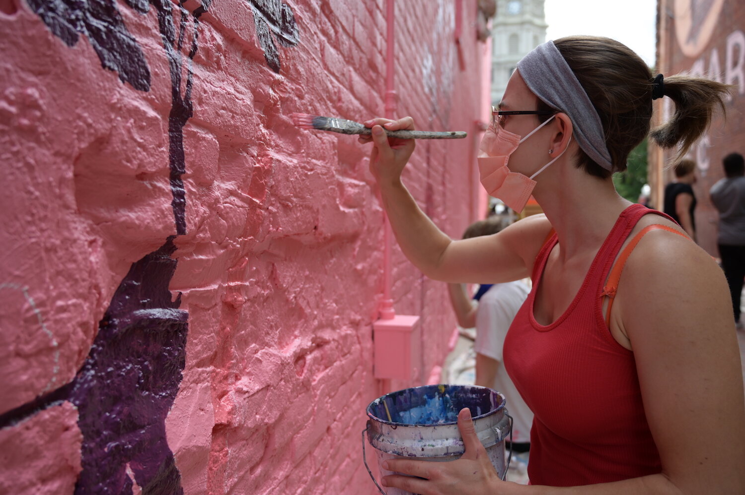 Artists assist Shawn Dunwoody with a mural in downtown Columbia City.