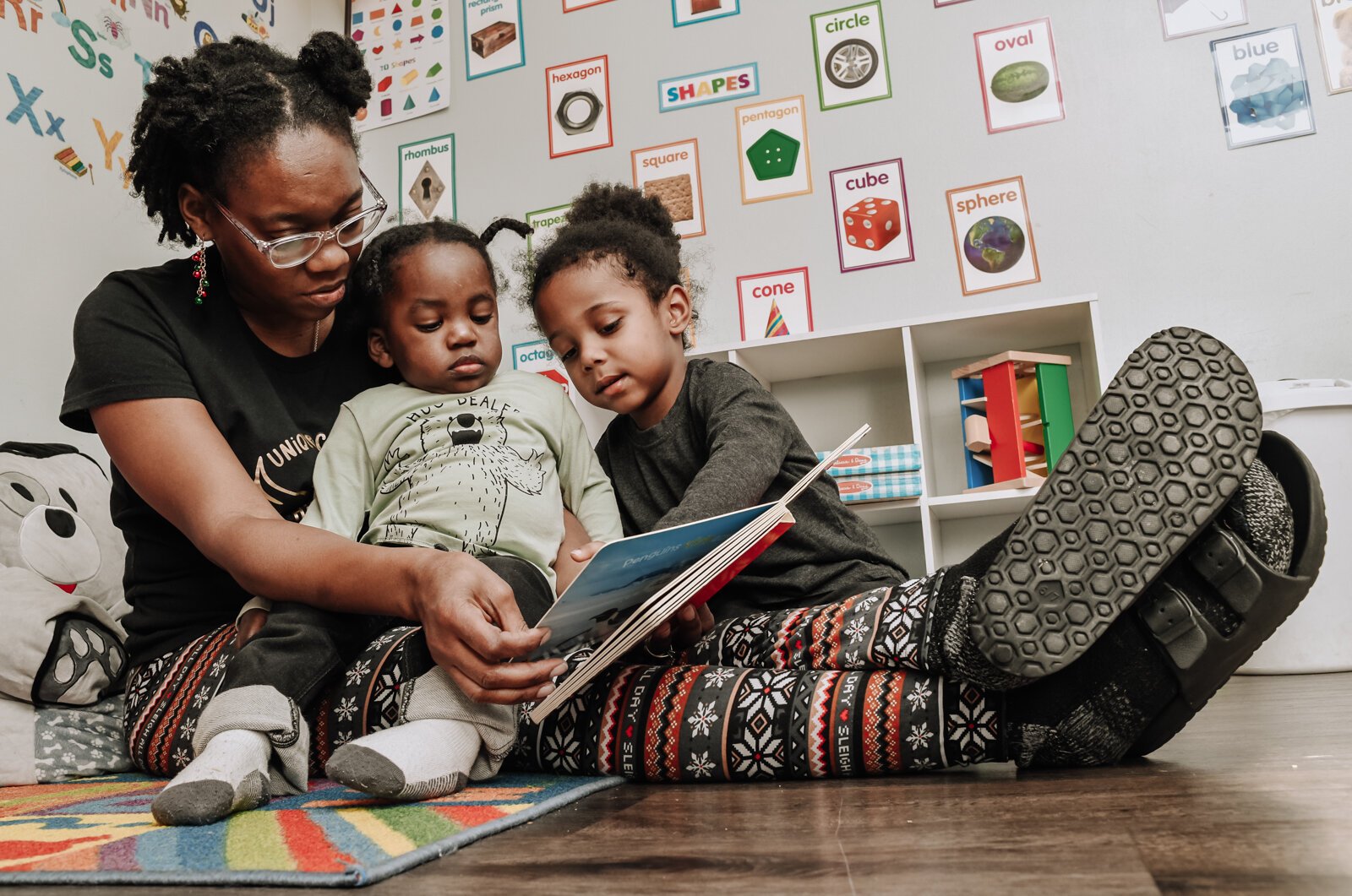 Deondra Steward, Owner of Unique Cherubs takes care of children, JereMias, left, and Domonique.