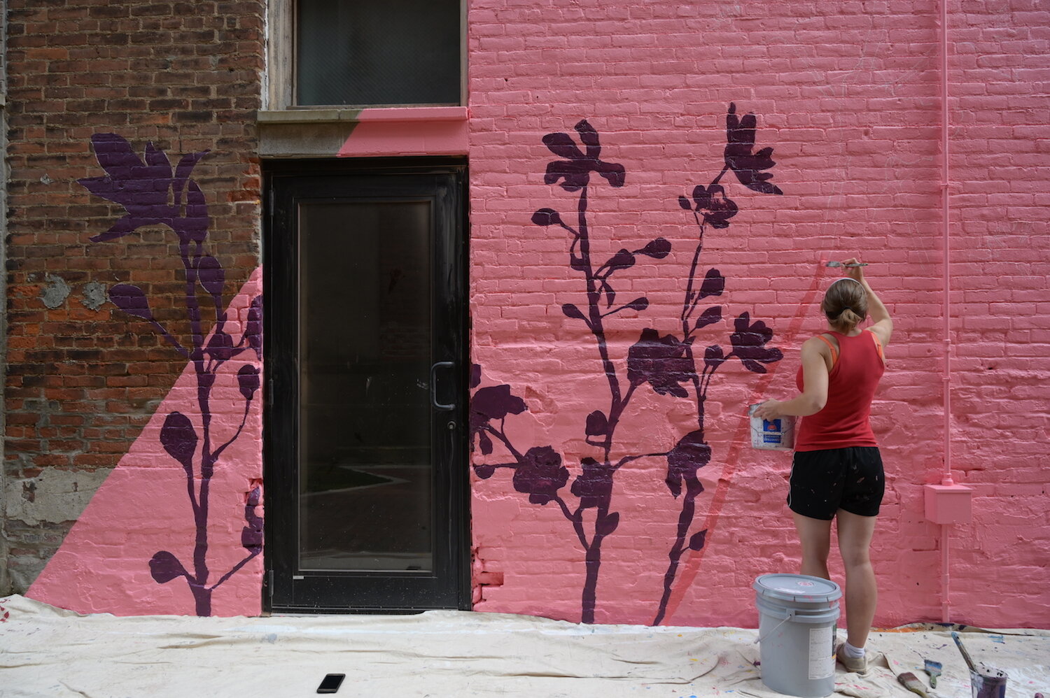 Artists assist Shawn Dunwoody with a mural in downtown Columbia City.