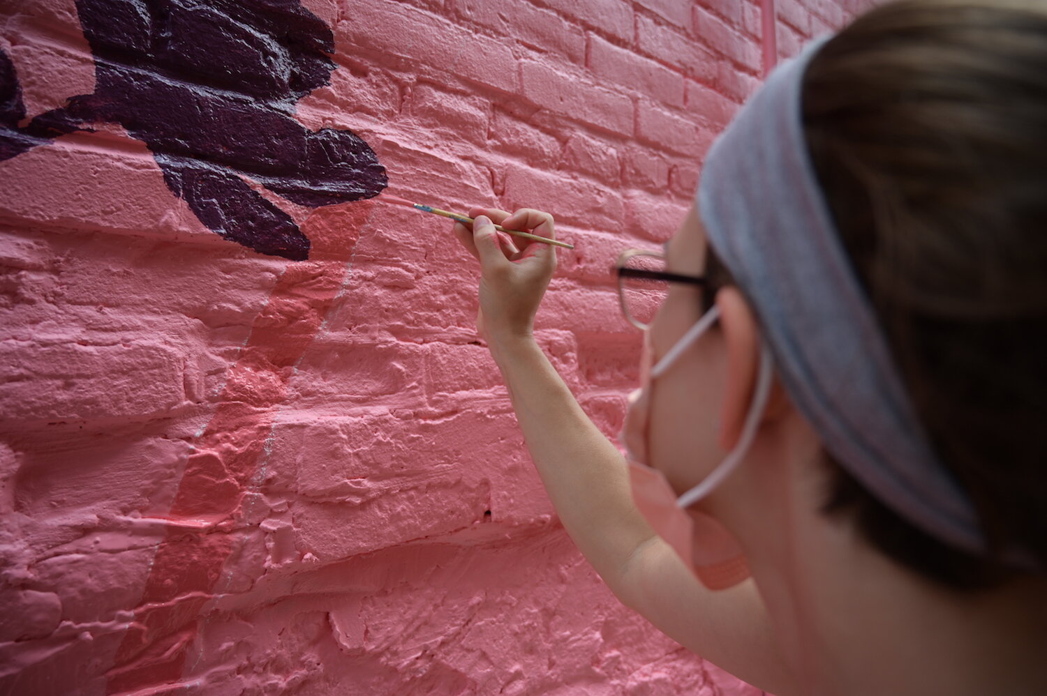 Artists assist Shawn Dunwoody with a mural in downtown Columbia City.