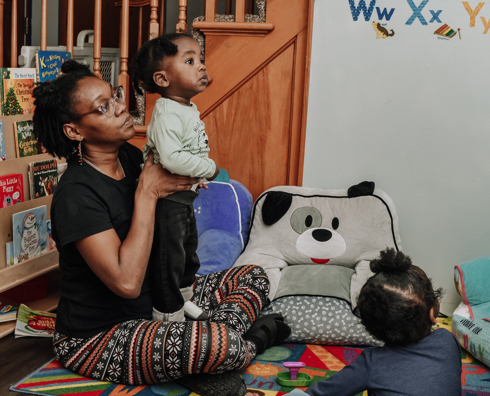 Deondra Steward, Owner of Unique Cherubs, takes care of children, like JereMias, during a learning activity.