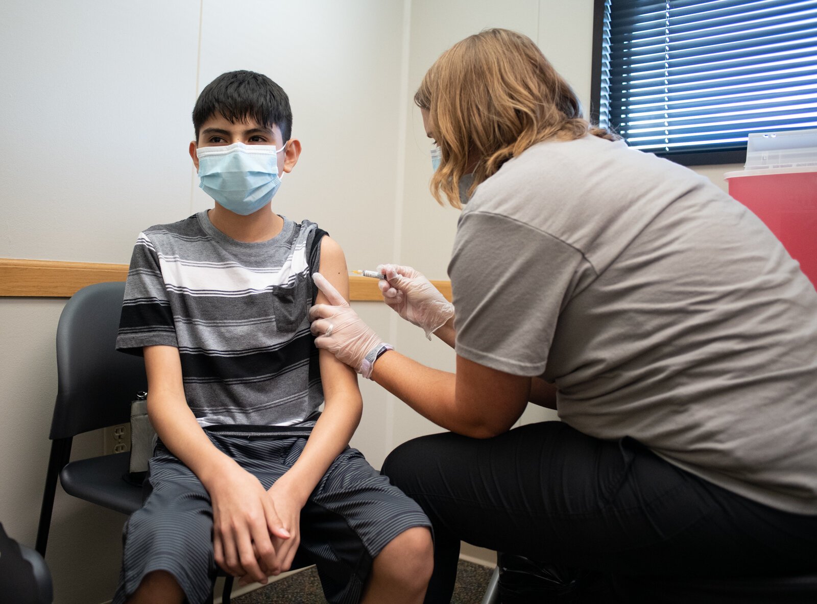 Anthony gets a school vaccination from Staci Kaczmarek at Super Shot, 1515 Hobson Road.