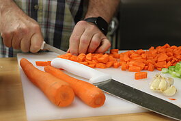 David Rigby, Ruth-Anne’s grandfather, helps shop up carrots as part of the Our HEALing Kitchen class at Shepherd’s House.