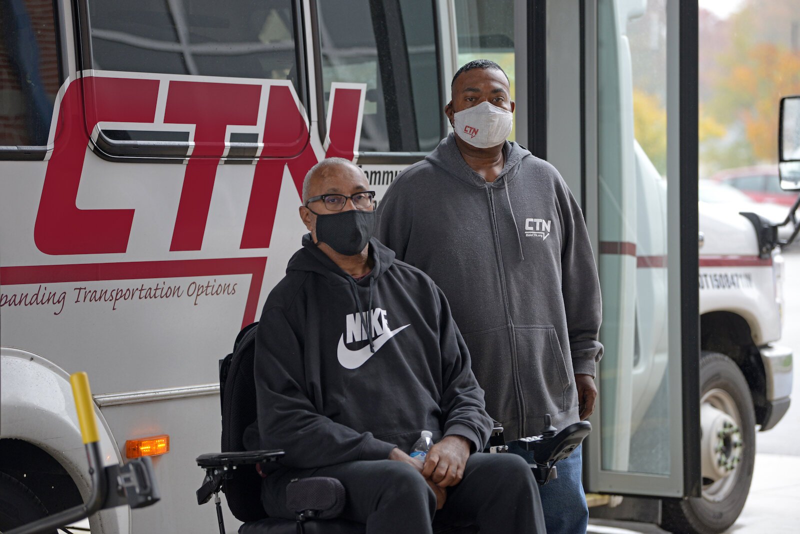 A rider and their guest outside of a CTN bus.