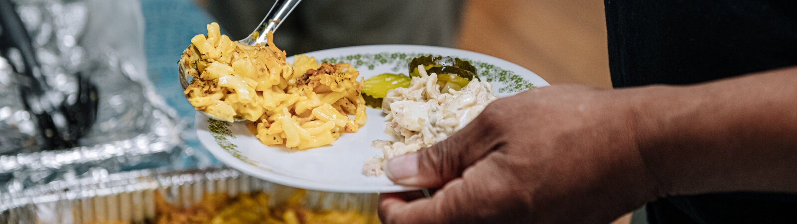 Kent Carter dips a plate during "Super Saturday" a free monthly community meal for the housing members at River's Edge, a supportive housing complex on Spy Run Ave. Ext. in Fort Wayne.