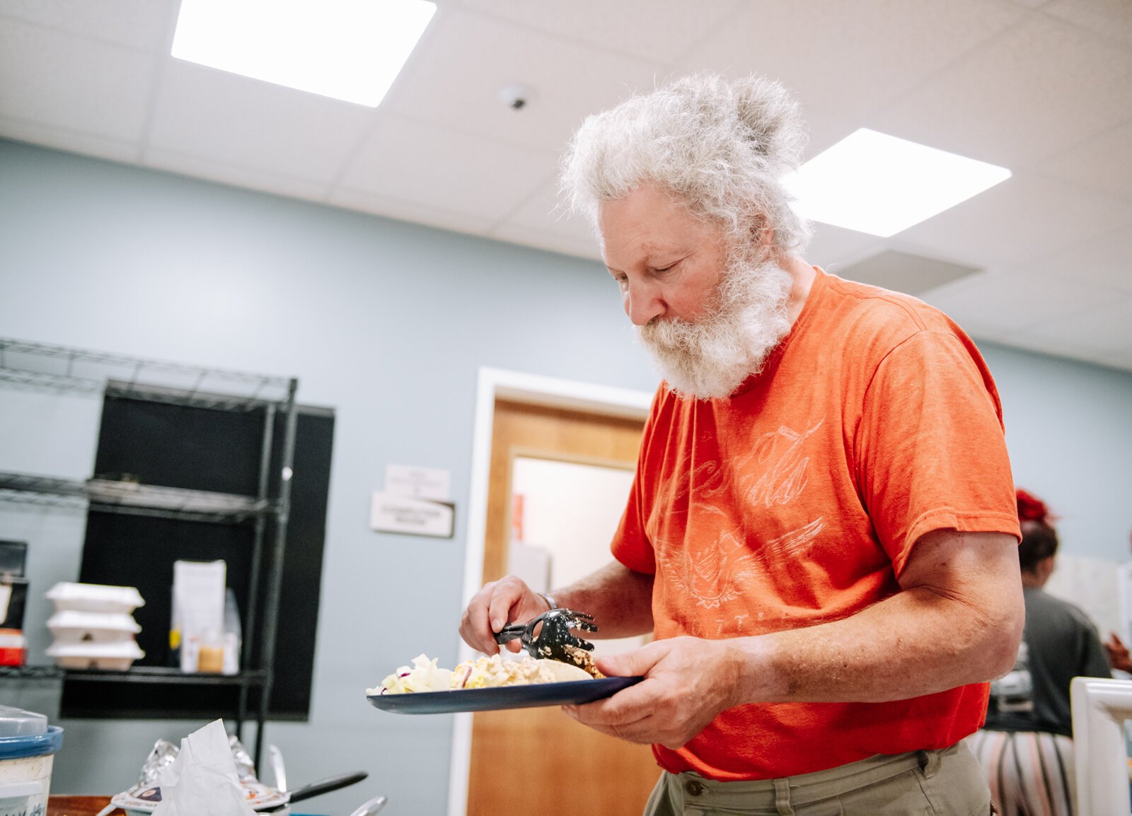 Pete Barbaruolo dips a plate during "Super Saturday" a free monthly community meal for the housing members at River's Edge. River's Edge is a  supportive housing complex on Spy Run Ave. Ext.