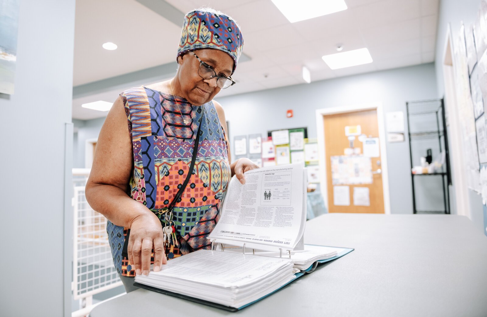 Denise Porter flips through her book of resources at River's Edge, a supportive housing complex on Spy Run Ave. Ext. in Fort Wayne.