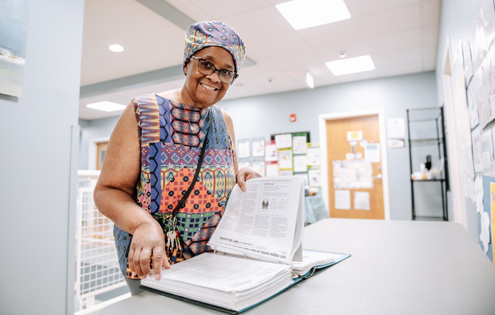 Denise Porter flips through her book of resources at River's Edge, a supportive housing complex on Spy Run Ave. Ext. in Fort Wayne.