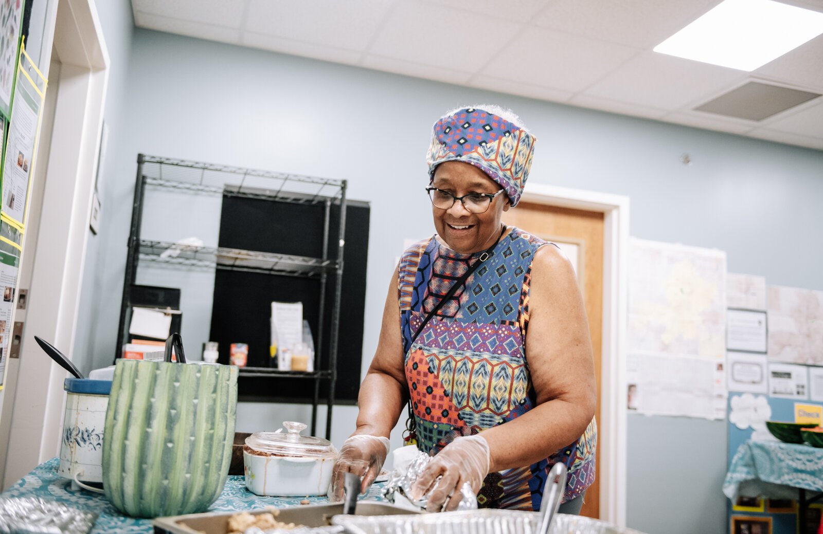 Community Leader Denise Porter works on organizing the food during "Super Saturday" a free monthly community meal for the housing members at River's Edge. River's Edge is a supportive housing complex on Spy Run Ave. Ext.