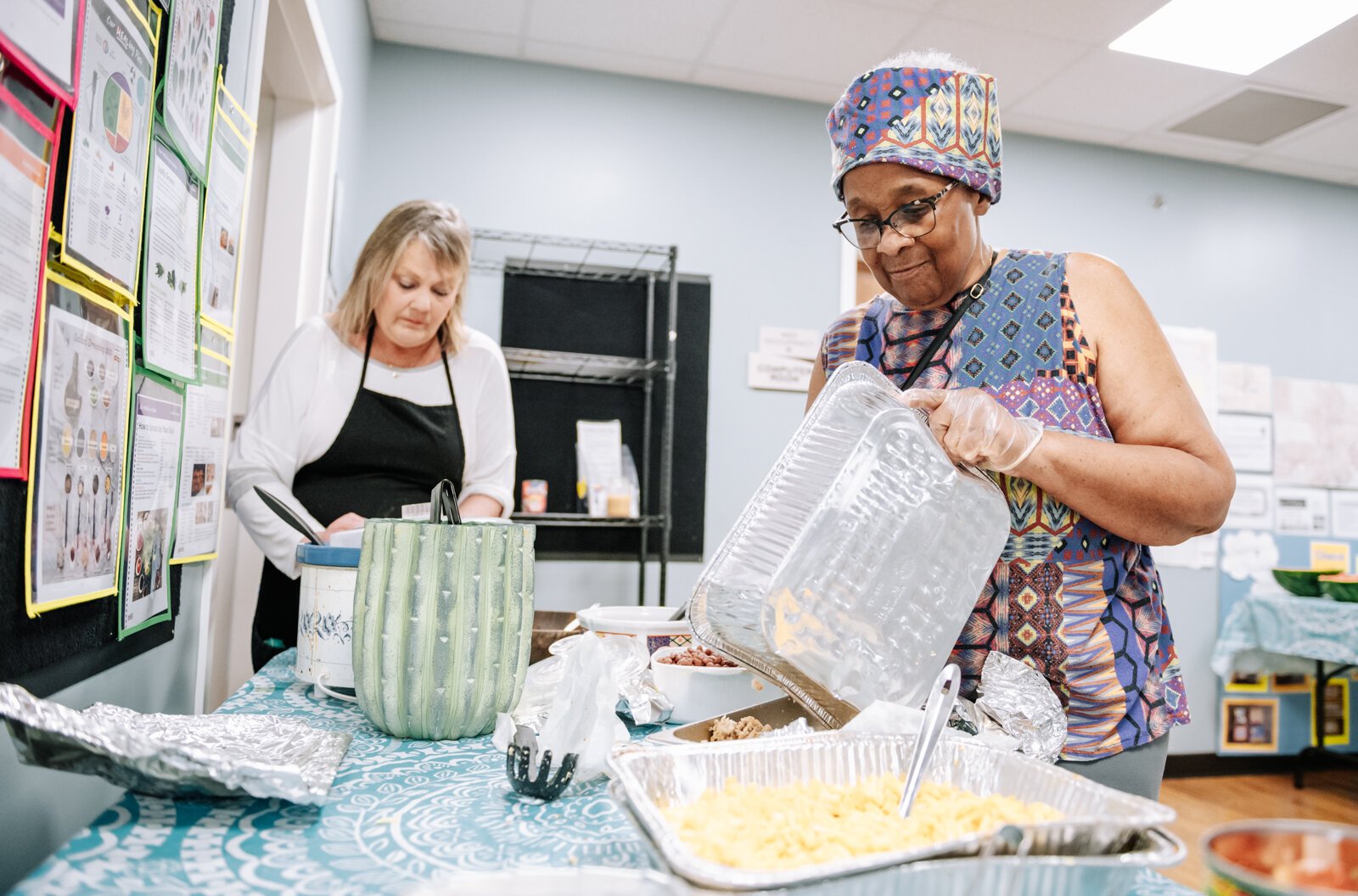 Community Leader Denise Porter works on organizing the food during "Super Saturday" a free monthly community meal for the housing members at River's Edge. River's Edge is a supportive housing complex on Spy Run Ave. Ext.