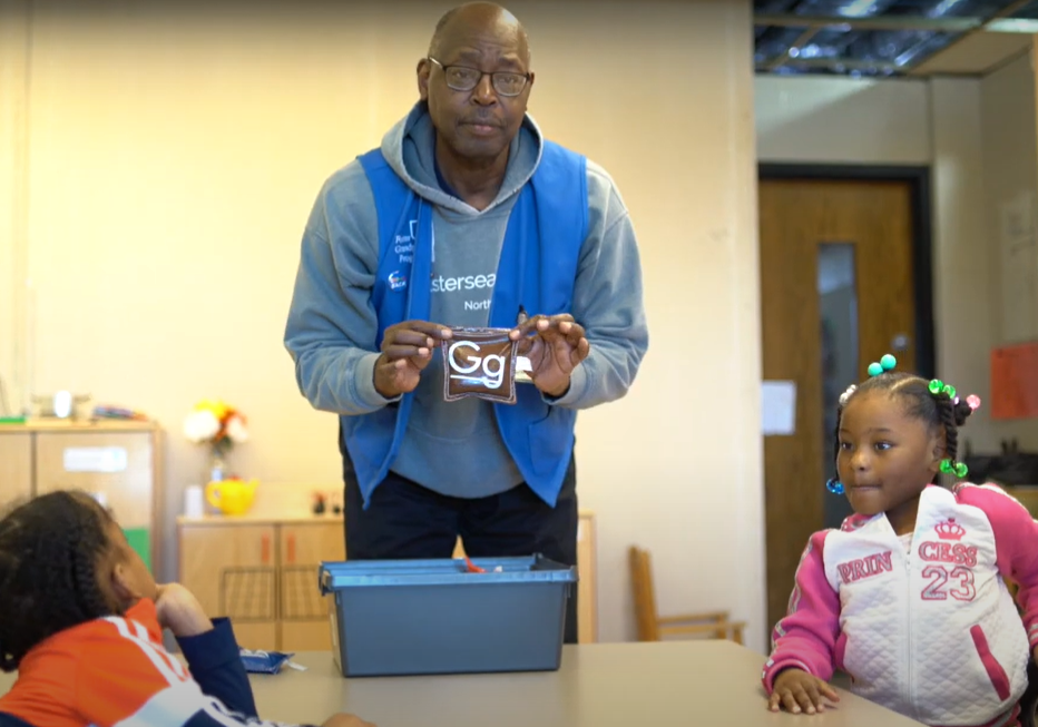 Dan, a foster grandparent, works with preschoolers on letter recognition.