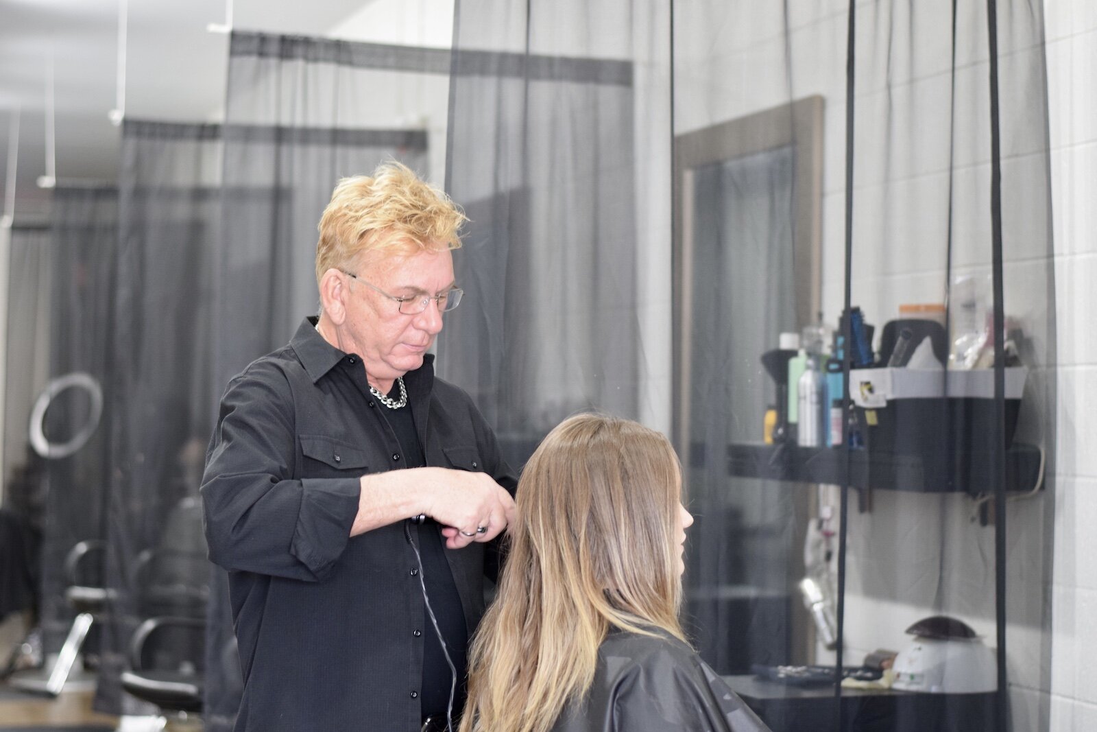 Michael Schram, owner of Michael Michael's Salon and Spa, styles a client's hair.