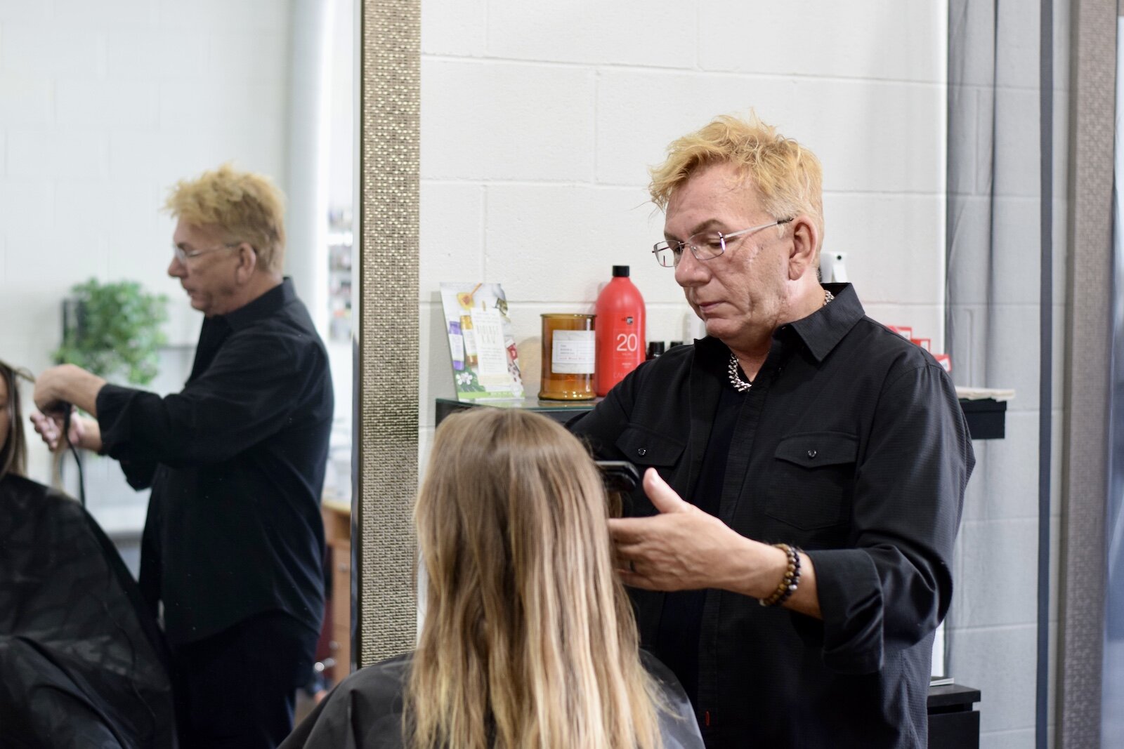 Michael Schram, owner of Michael Michael's Salon and Spa, styles a client's hair.