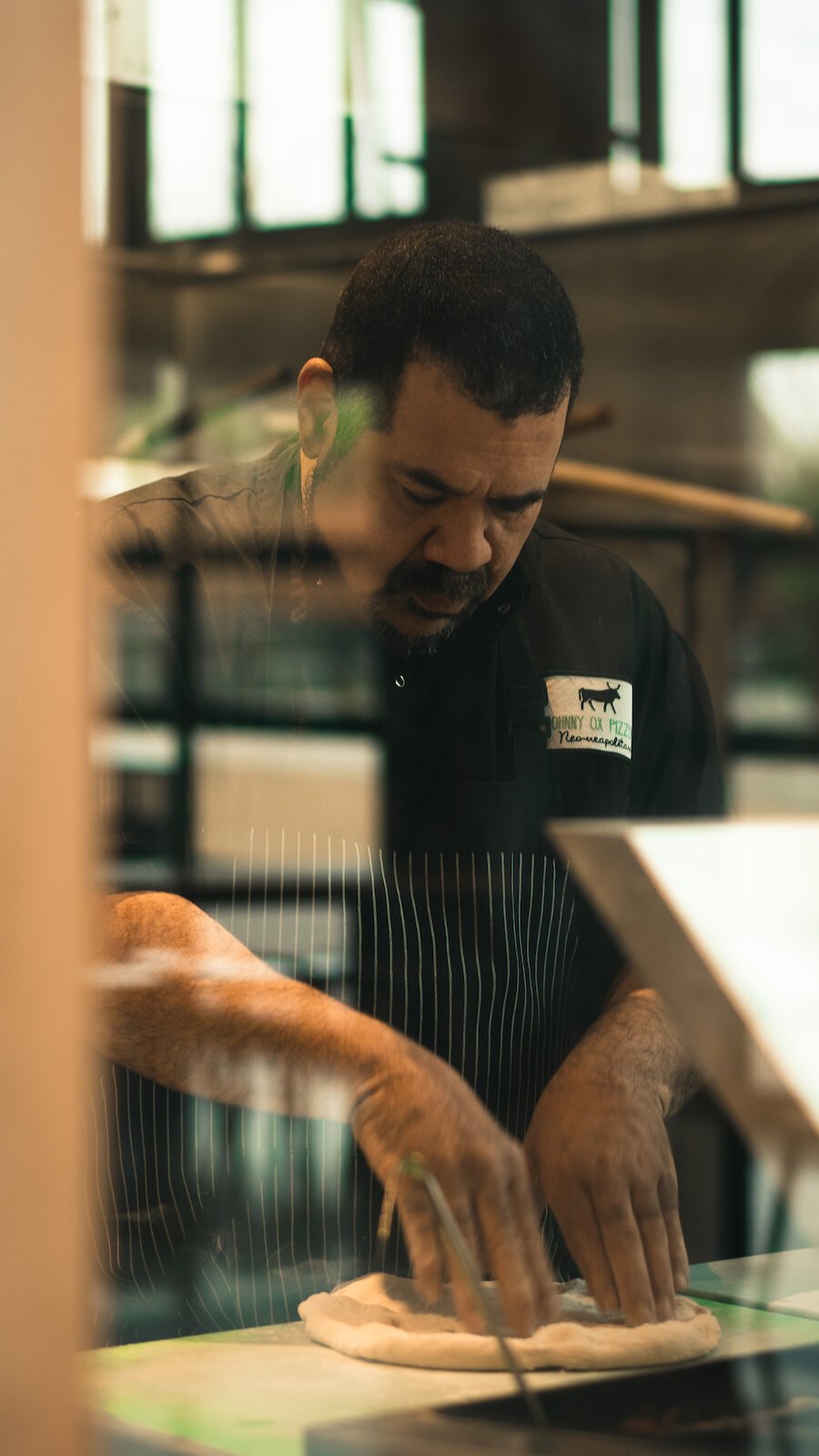 Johnny Bojinoff, owner of Johnny OX Pizzeria, works dough for a pizza.