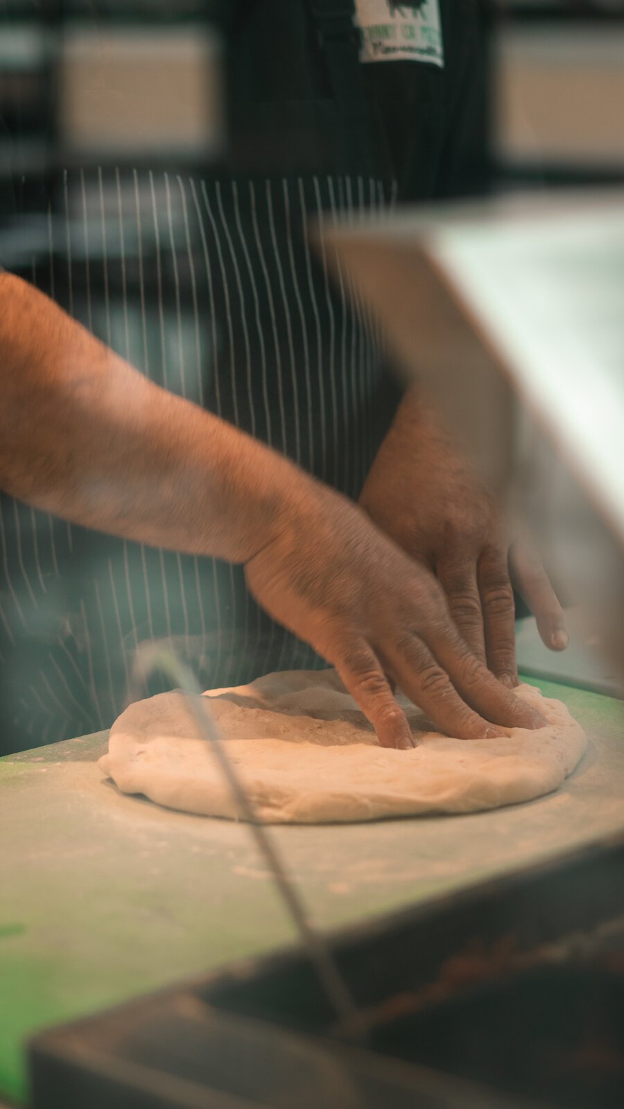 Johnny Bojinoff, owner of Johnny OX Pizzeria, works dough for a pizza.