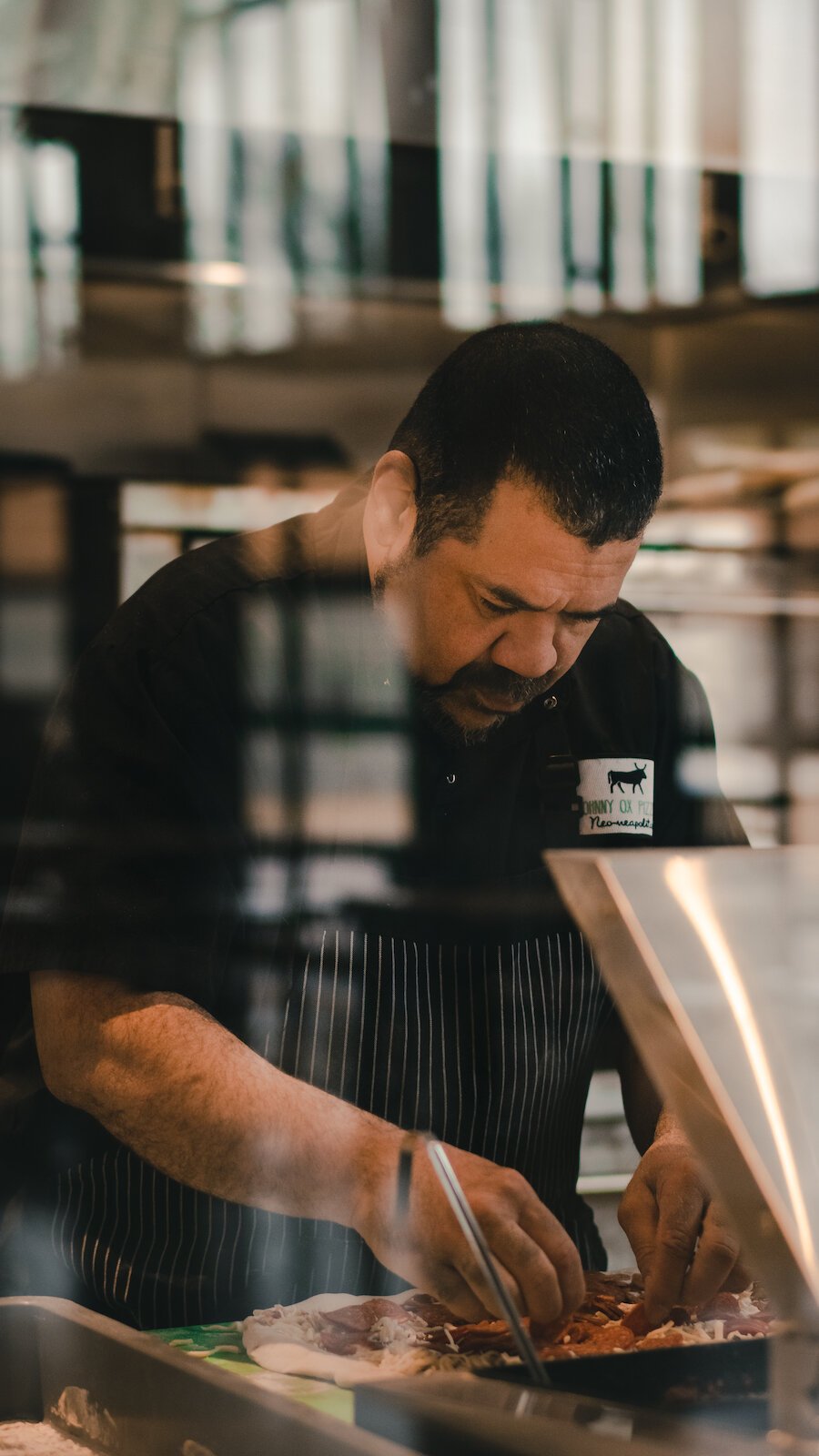 Johnny Bojinoff, owner of Johnny OX Pizzeria, works on a pie.