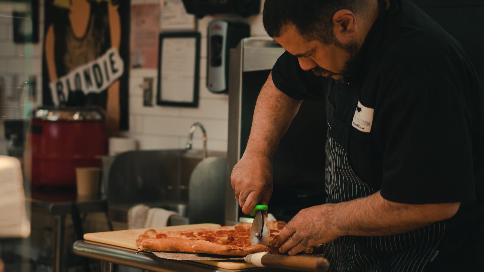 Owner of Johnny OX Pizzeria, Johnny Bojinoff, cuts a freshly made pizza.