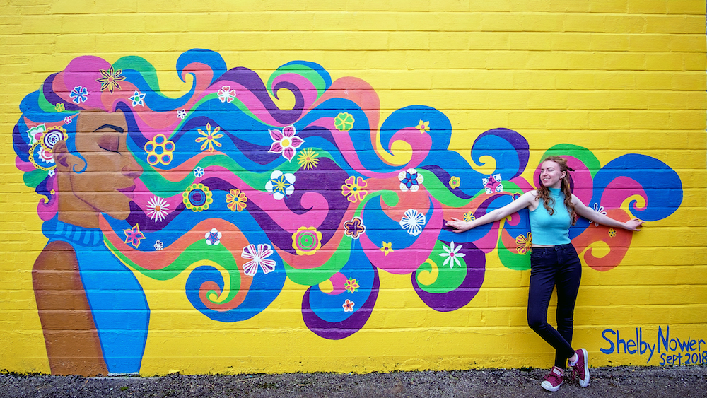 Art student Shelby Nower, 21, stands in front of her mural in downtown Decatur.