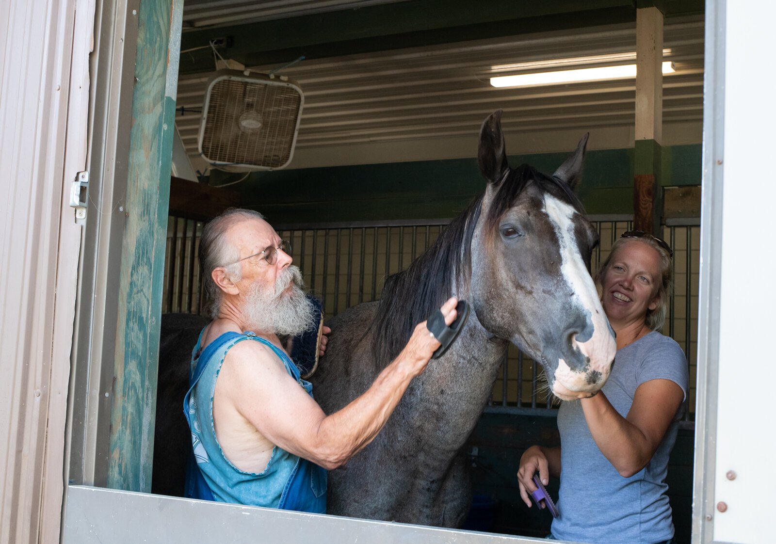 Allison Wheaton and veteran Randal Clemens work together to groom horse Mojo at Summit Equestrian Center, 10808 La Cabreah Ln.