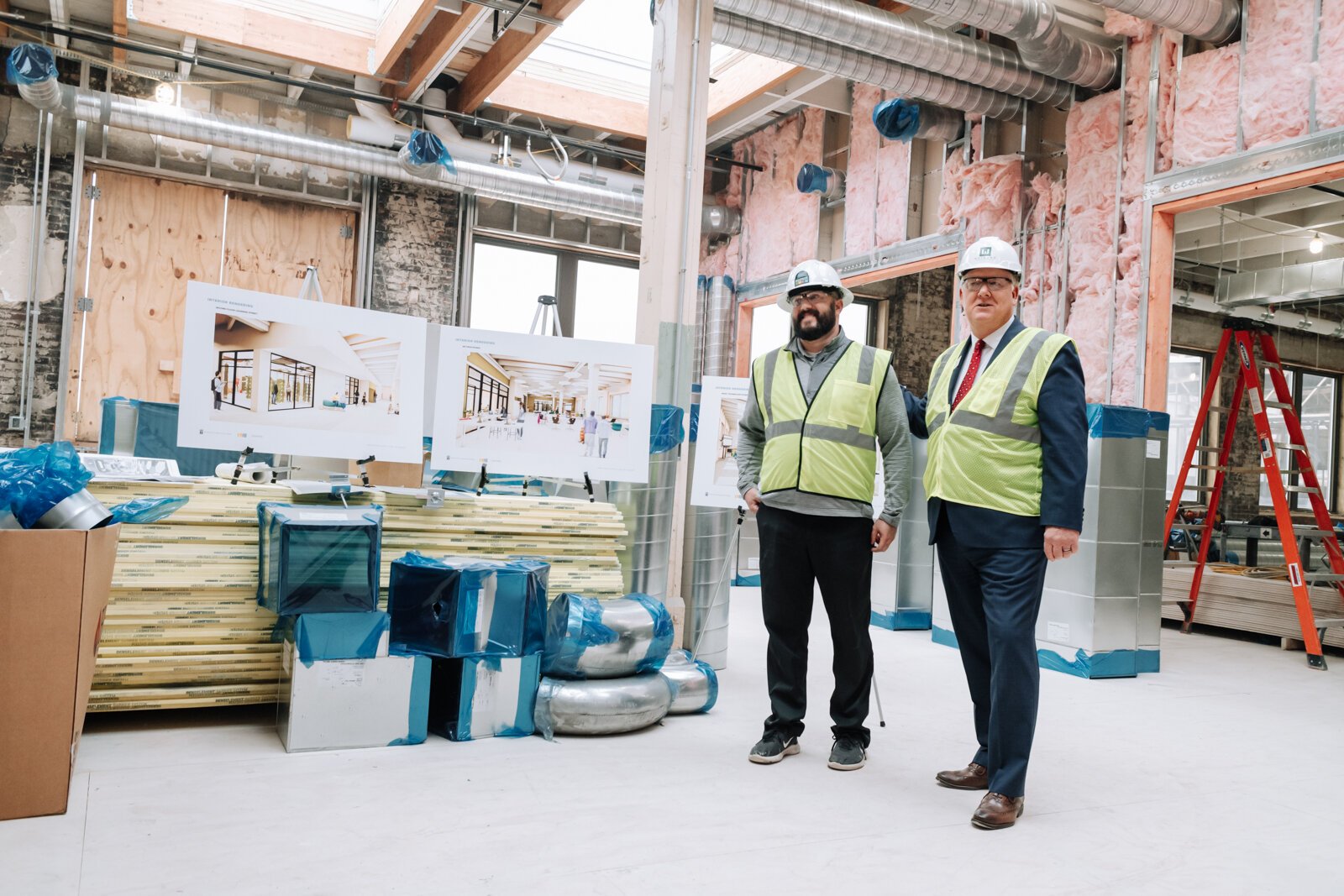 Riley Johnson, left, Director of the Amp Lab at Fort Wayne Community Schools, speaks with members of the media inside the Amp Lab's future space in Building 31 of Electric Works. (December 2021) 