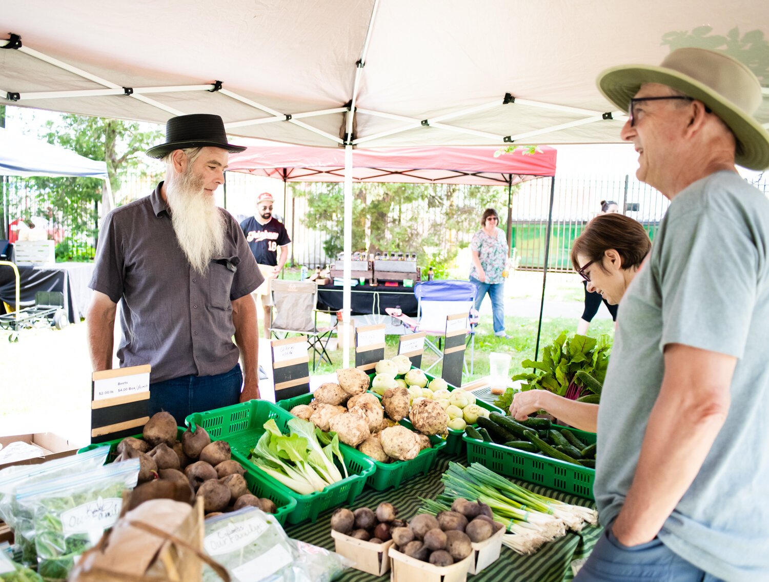 Myron Metzger with Berry Hill Farm helps customers during the Fort Wayne's Farmers Market at McCulloch Park on Saturday June 19, 2021.